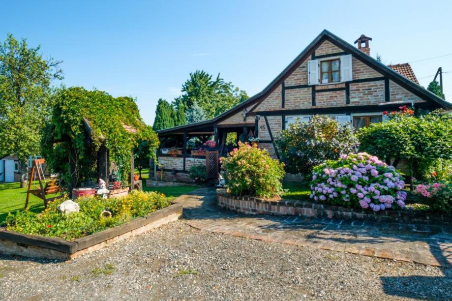 una vecchia casa con dei fiori davanti di Kuća za najam - IMANJE LUNA BAZEN JACUZZI a Sveti Ivan Žabno