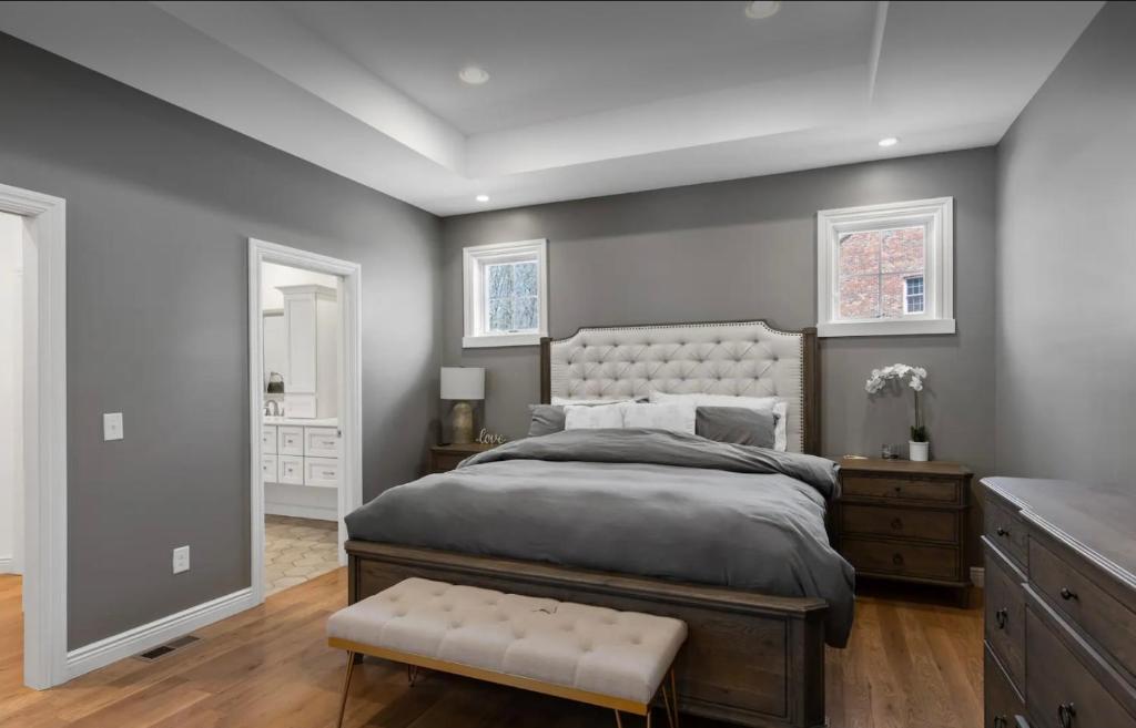 Schlafzimmer mit einem großen Bett mit einem weißen Kopfteil in der Unterkunft Custom Home & Located 20min to Downtown Saratoga Springs - Belmont Stakes in Schenectady