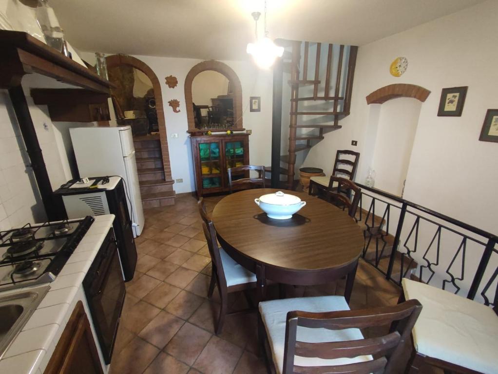 een keuken en eetkamer met een tafel en stoelen bij La grotta dei nonni in Sassa