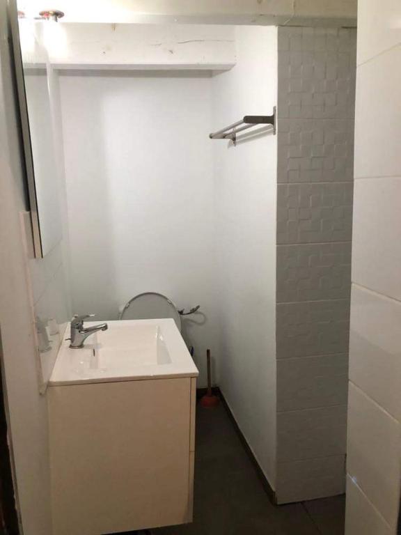 een witte badkamer met een wastafel en een douche bij Le William in Marseille