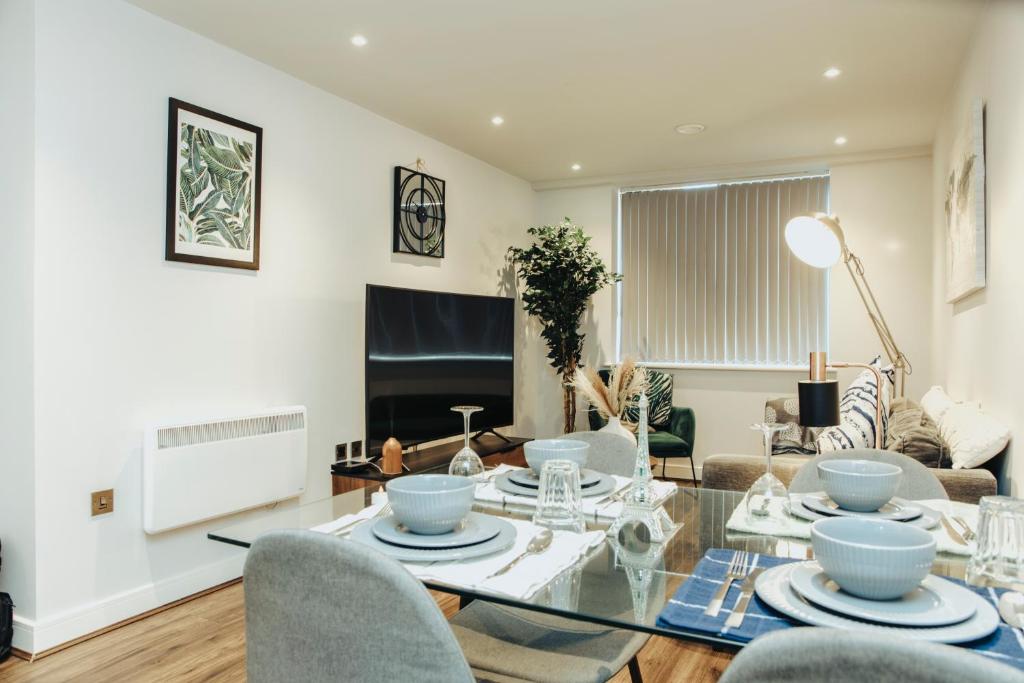 a living room with a glass table and chairs at Stunning 2-Bed Apartment in Birmingham City Center in Birmingham