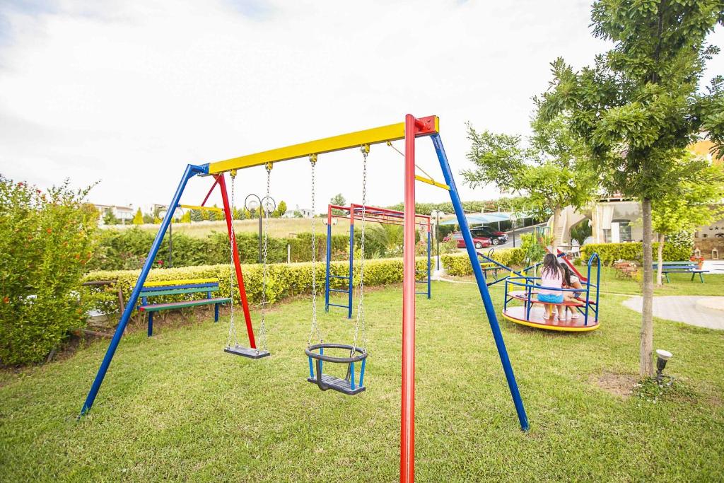 a playground with two swings and a bench at Sunny Hill in Sani Beach