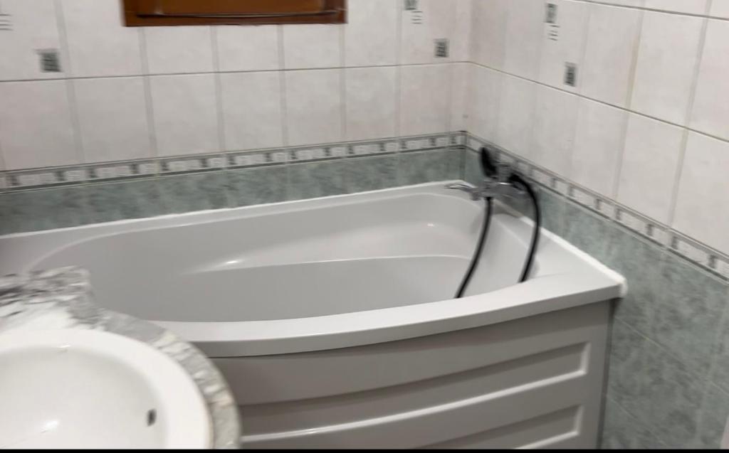 La salle de bains est pourvue d'une baignoire blanche et d'un lavabo. dans l'établissement Casita, au Blanc-Mesnil