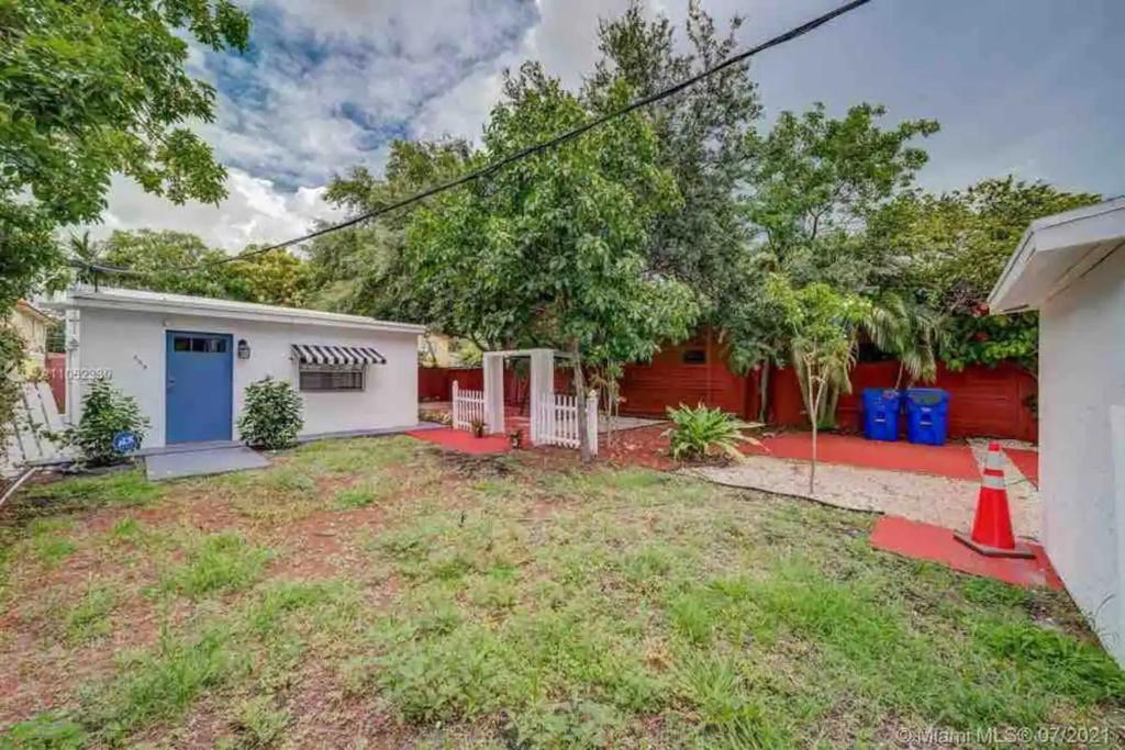 a home with a red fence and a yard at Cozy Private House near Miami Airport - Free parking - 02 in Miami