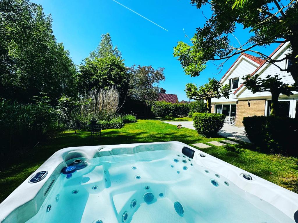 a hot tub in the yard of a house at VILLA CALMA Rust Ruimte Luxe inclusief private jacuzzi in Zeewolde