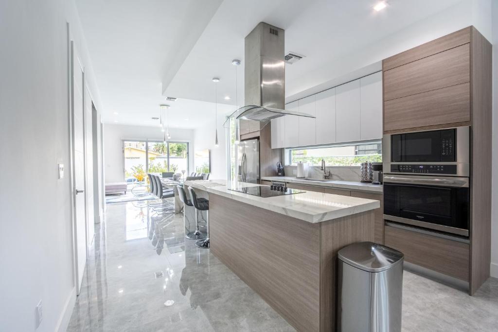 a kitchen with a counter with a stove top oven at Modern 4-Bedroom Townhouse with Pool! in Miami