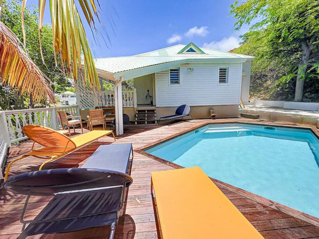 una piscina con sedie e una casa di Villa Bulle clothing optional around the prival pool a Orient Bay