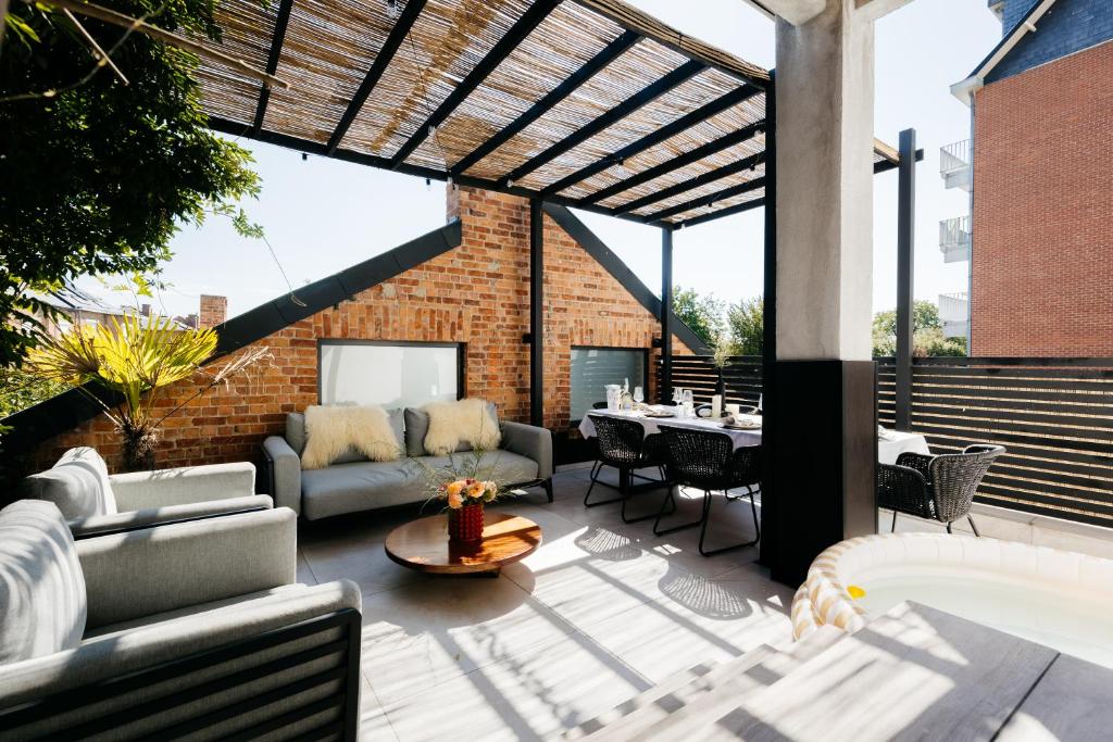 un patio con sofás, una mesa y una pared de ladrillo en The Edgewater Suites - Park View en Namur