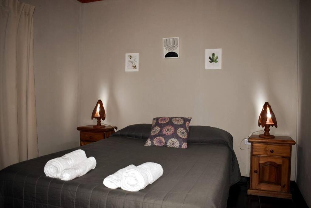 1 dormitorio con 1 cama con toallas en Cabaña Finca el Oasis en Jáchal, San Juan en San José de Jáchal