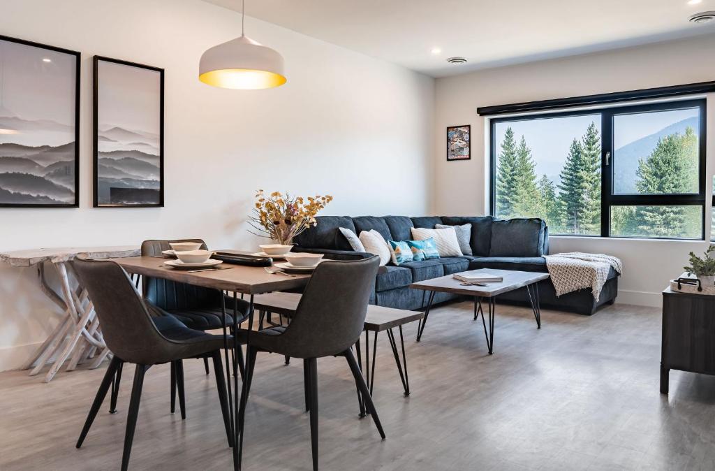 a living room with a blue couch and a table and chairs at Slopes and Greens by Revelstoke Vacations in Revelstoke