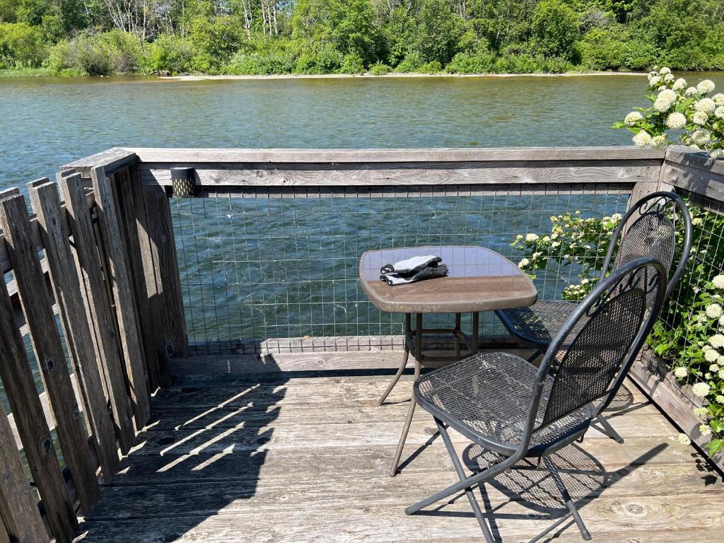een tafel en twee stoelen op een terras naast het water bij River house in Campbell River