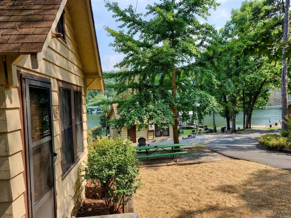 a building with a window and a bench next to a lake at #06 - Lakeview Two Bedroom Cottage-Pet Friendly in Hot Springs