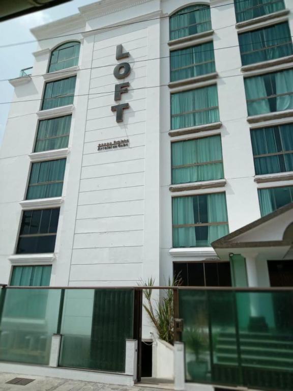 a tall white building with a sign on it at Loft na Prainha - Arraial do Cabo in Arraial do Cabo