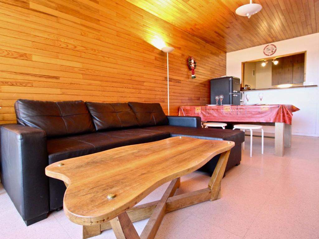 un soggiorno con divano e parete in legno di Appartement Chamrousse, 3 pièces, 8 personnes - FR-1-549-70 a Chamrousse