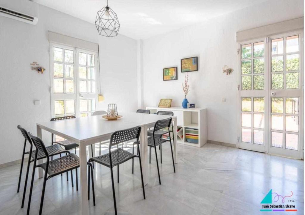 ein Esszimmer mit einem weißen Tisch und Stühlen in der Unterkunft Casa Juan Sebastian Elcano in Gelves