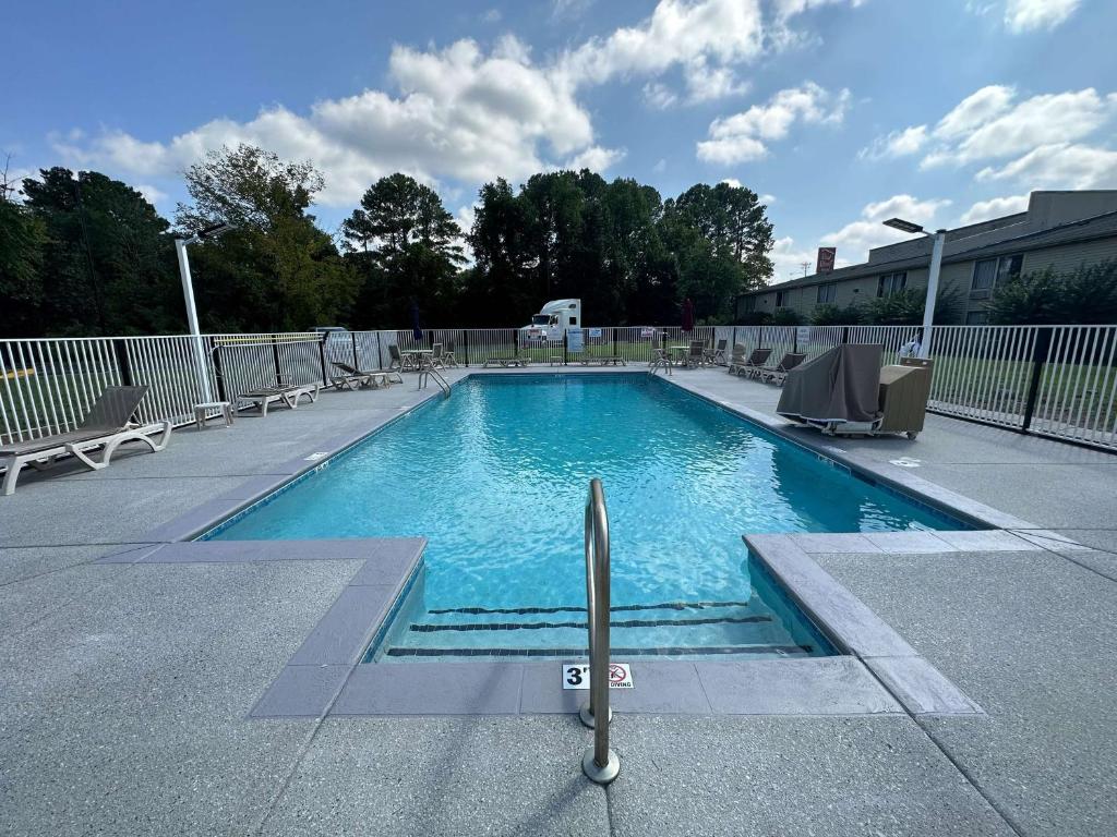 a large swimming pool with chairs at Motel 6-Greensboro, NC - Airport in Greensboro