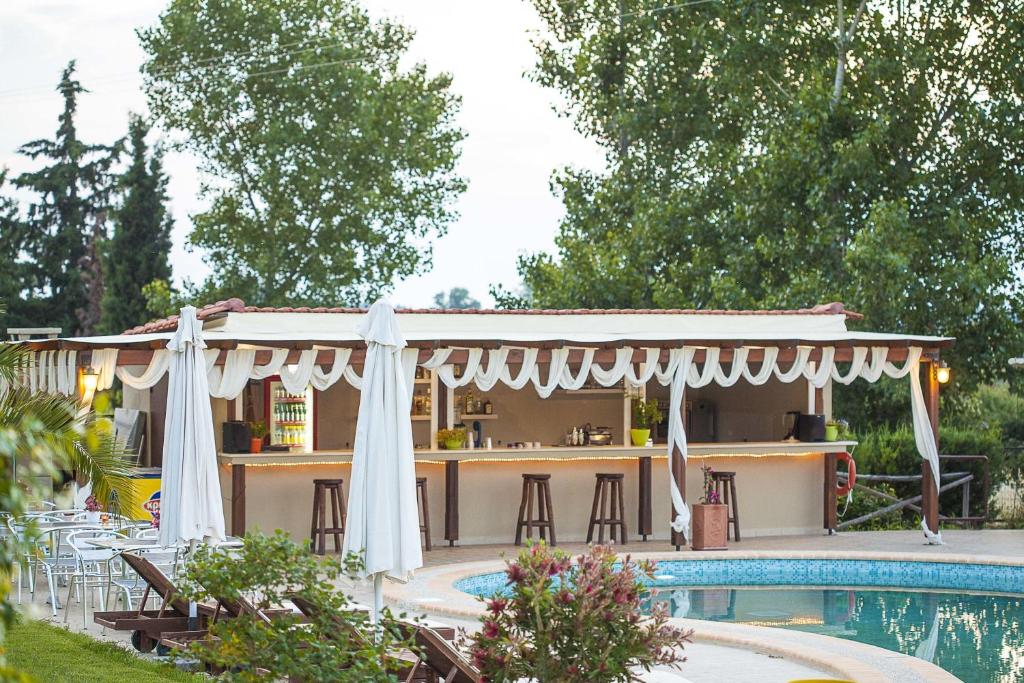 a pergola over a swimming pool next to a house at Sunny Hill in Sani Beach