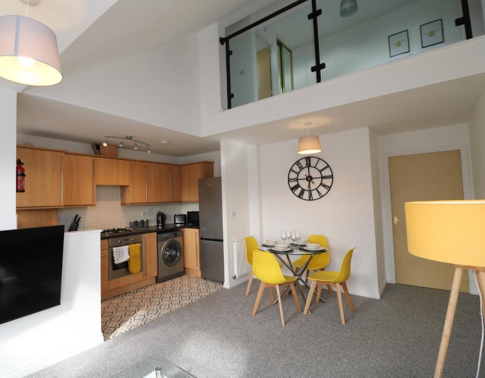 a kitchen and dining room with a table and chairs at Two Bedroom Peaceful Penthouse in Coventry