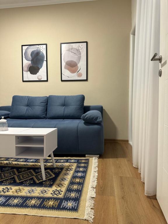 a living room with a blue couch and a table at BLUE APARTMENT MOSTAR in Mostar