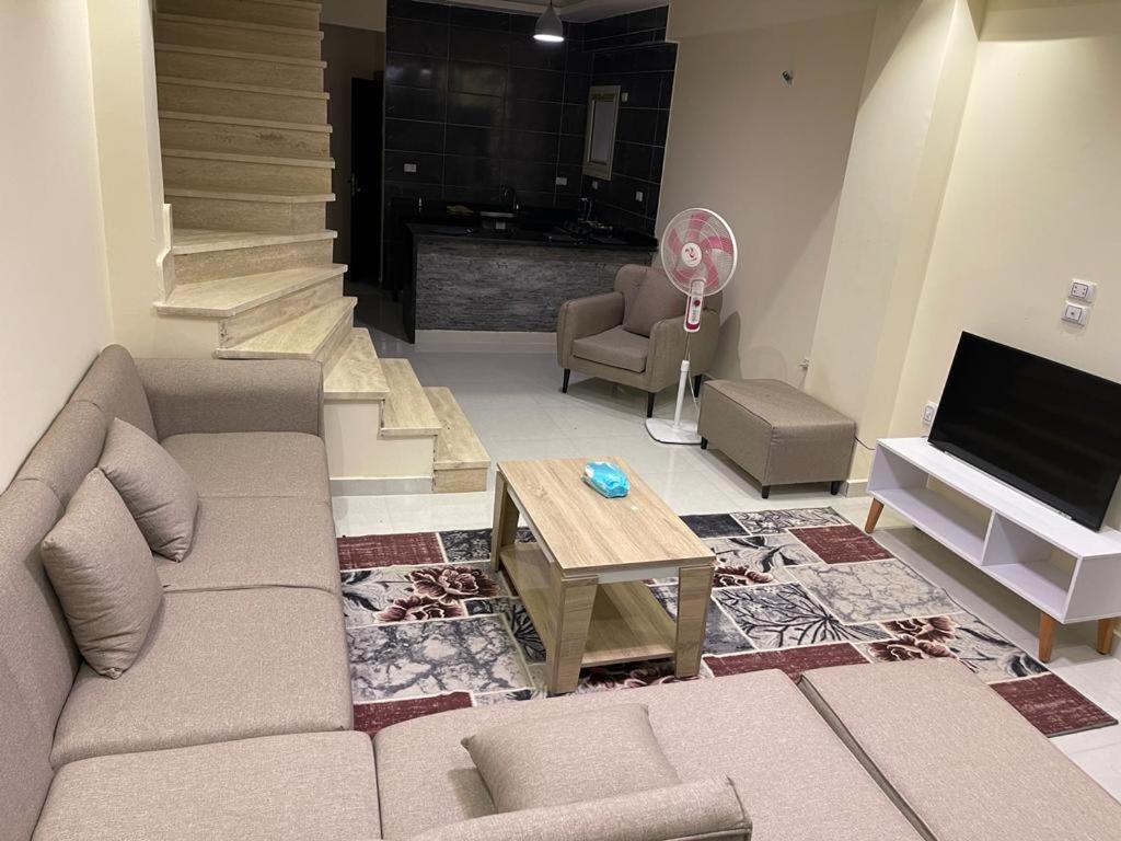 sala de estar con sofá y mesa en فيلا بقريه فرح ٢ الساحل الشمالي en El Alamein