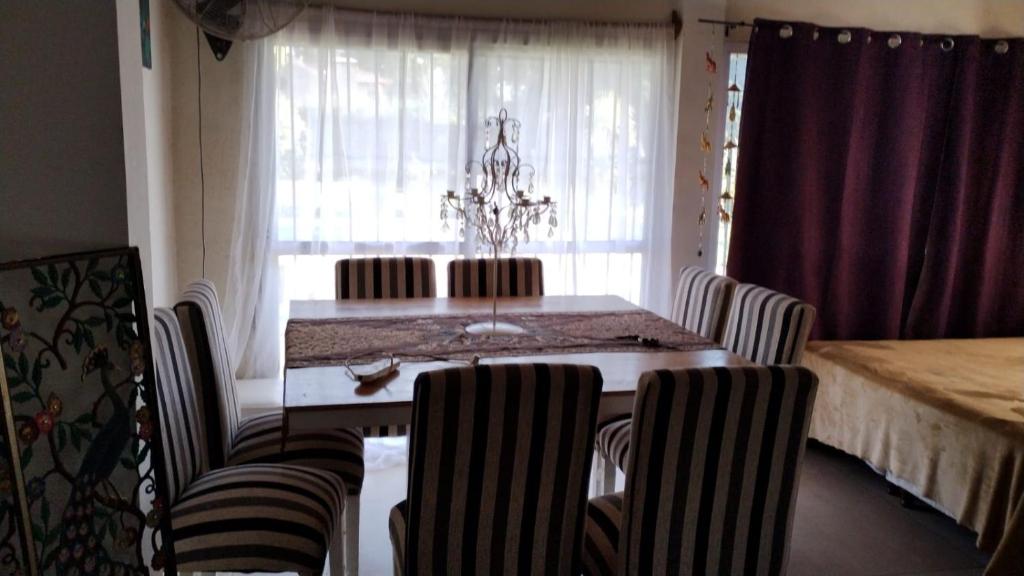 d'une salle à manger avec une table, des chaises et une fenêtre. dans l'établissement Casa Quinta con pileta Tortuguitas Bs As, à Manuel Alberti
