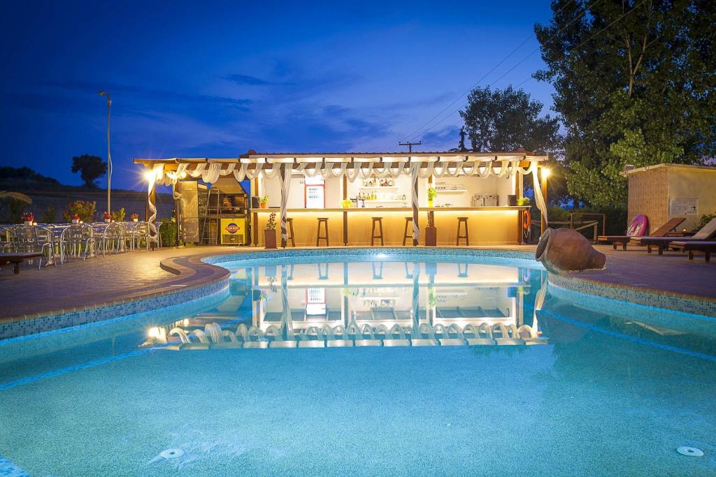 a swimming pool in front of a house at night at Sunny Hill in Sani Beach