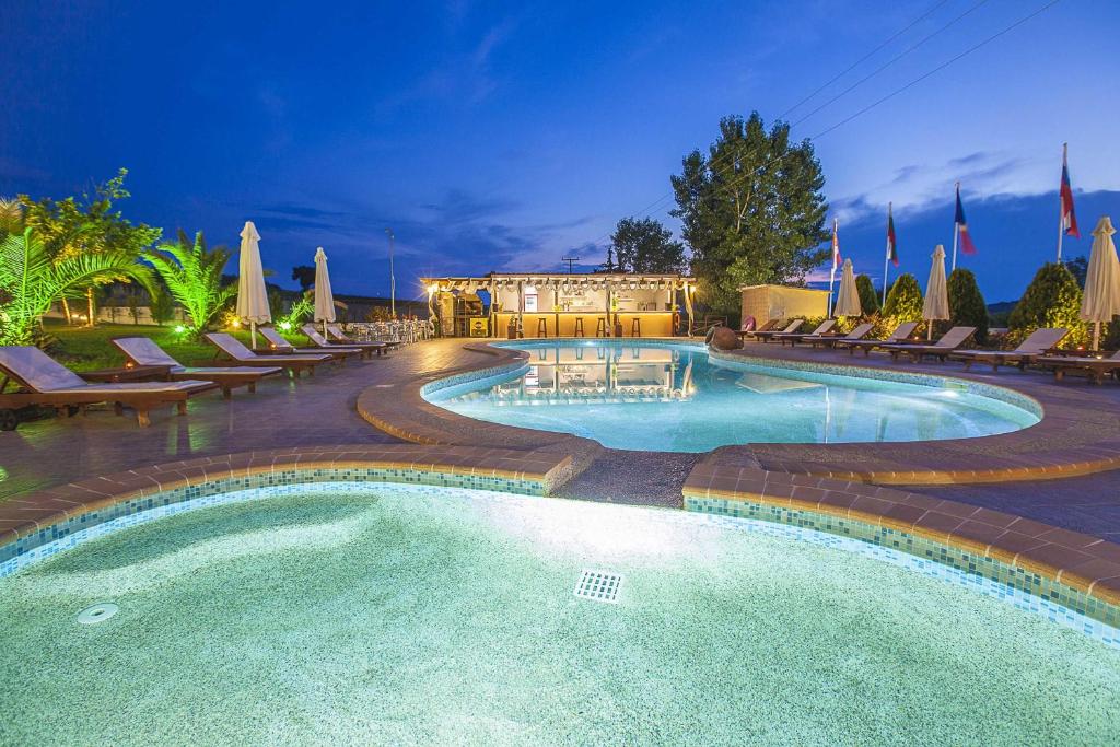 a large swimming pool with chairs and a building at Sunny Hill in Sani Beach
