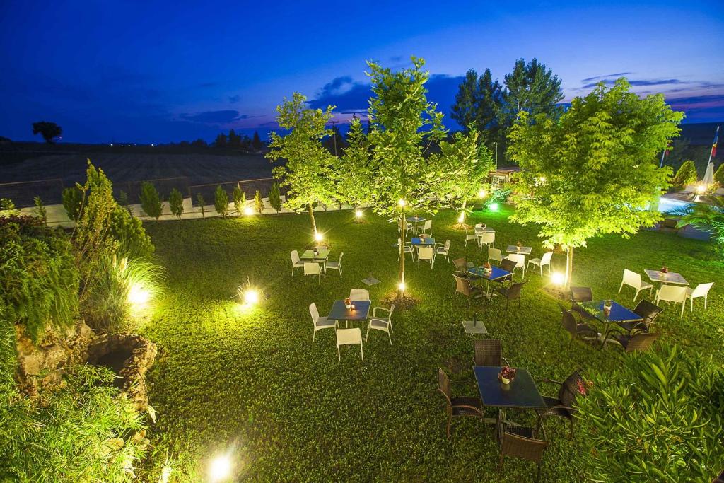 a garden with tables and chairs at night with lights at Sunny Hill in Sani Beach