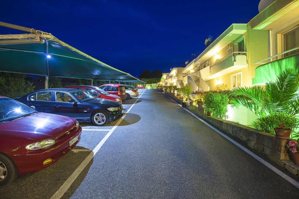 a row of cars parked in a parking lot at night at Sunny Hill in Sani Beach