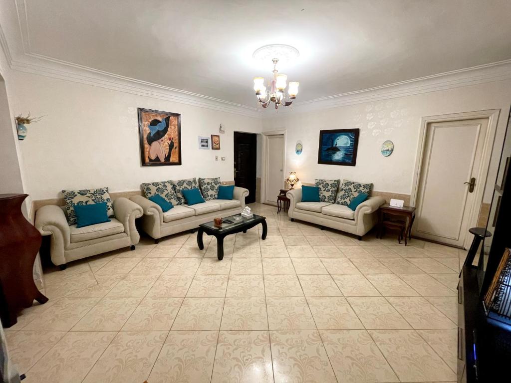uma grande sala de estar com sofás e uma mesa em The Cozy Smoozy no Cairo