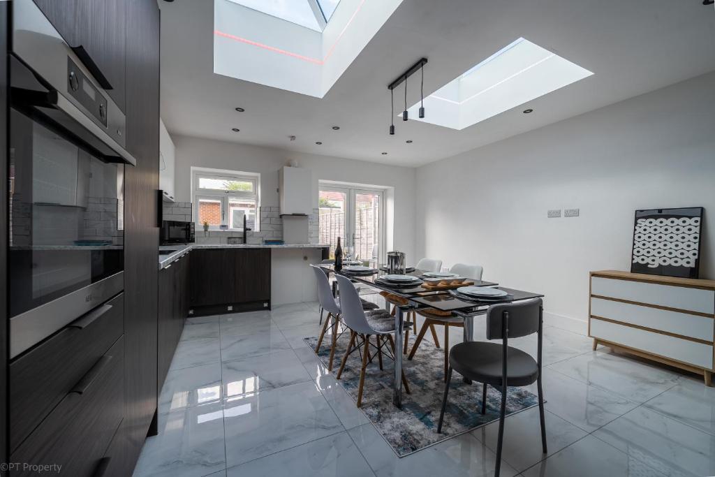 a kitchen and dining room with a table and chairs at Modern 5 bed home in Ealing, free driveway parking, sleeps 8 in Harrow on the Hill