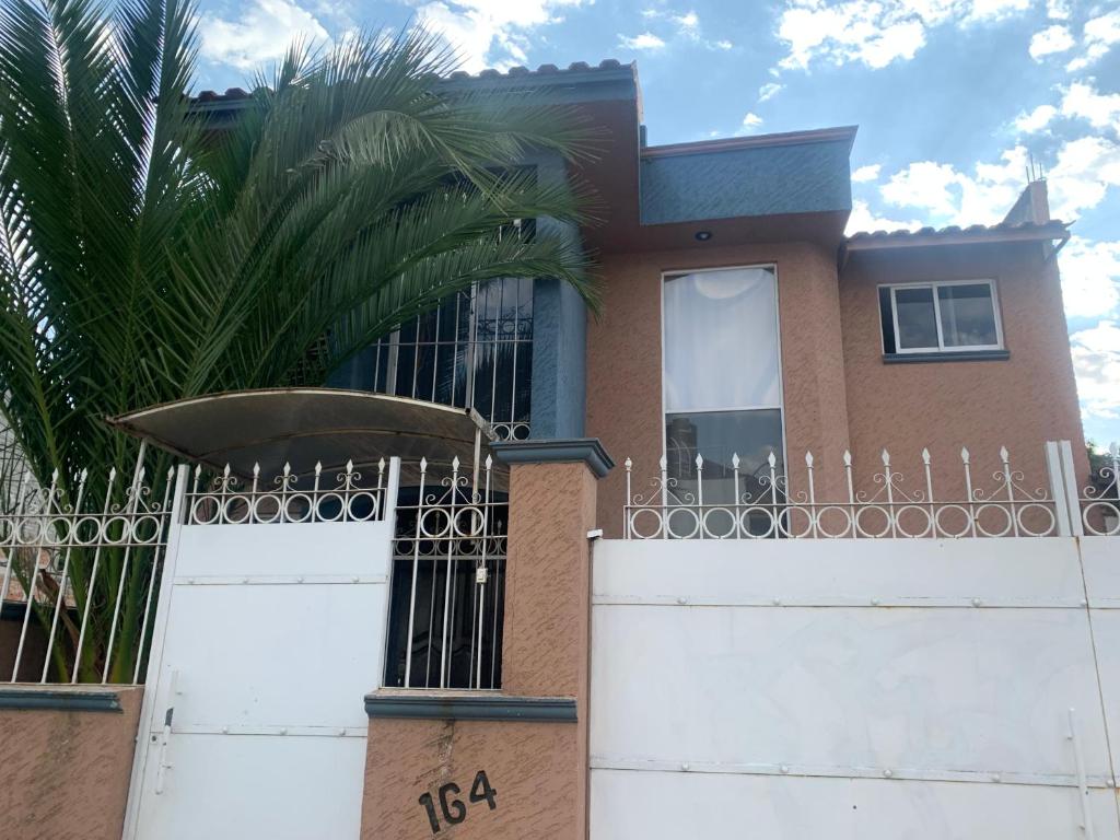 a house with a gate and a palm tree at Casa en Pátzcuaro in Pátzcuaro