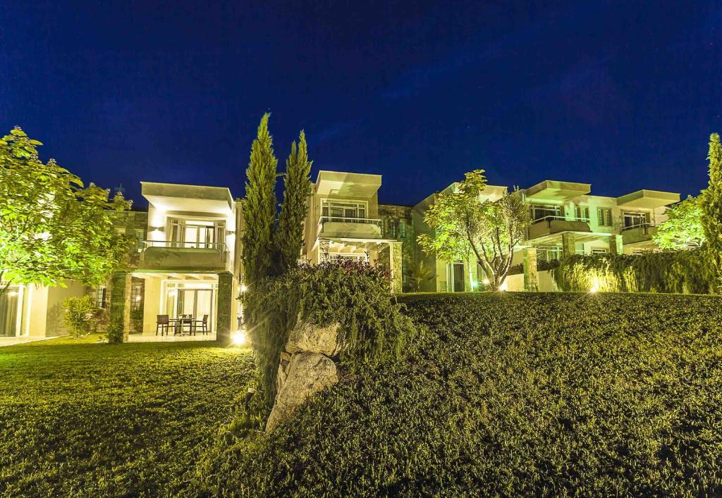 a large house on a hill at night at Sunny Hill in Sani Beach