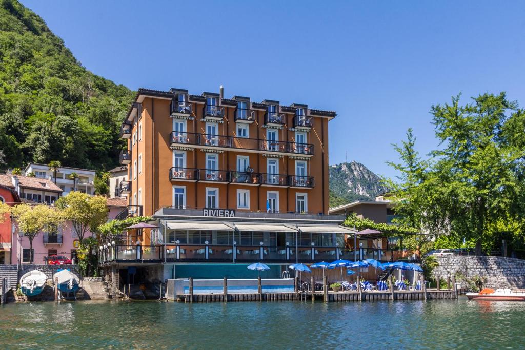 ein Hotel am Wasser neben einem See in der Unterkunft Hotel Riviera in Melide