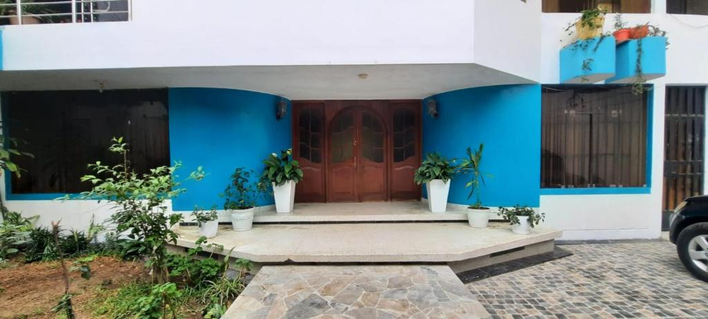 una casa con paredes azules y una puerta roja en CASA TESORITOS, en Urbanizacion Buenos Aires