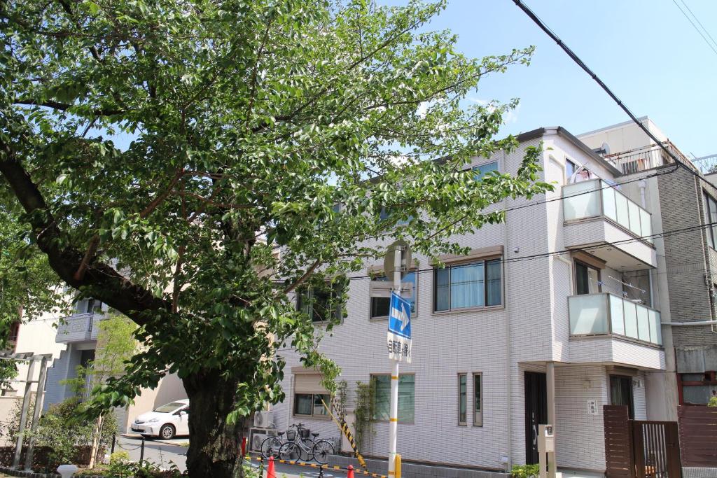 um edifício com uma árvore em frente em 京都LanLan em Quioto