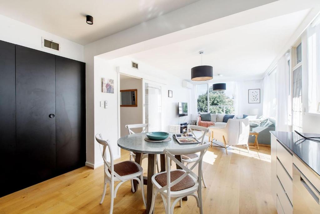 a kitchen and living room with a table and chairs at Edge of Elwood - Unwind in Style by St Kilda Beach in Melbourne