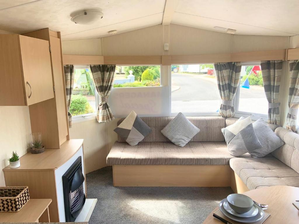 a living room with a couch and a tv at The Beeches in Lincolnshire