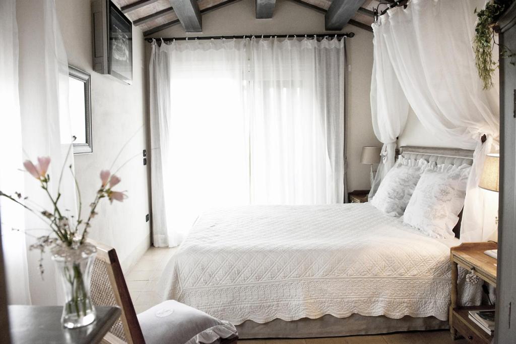 1 dormitorio con cama blanca y ventana en Casina Le Conserve, en Cesenatico