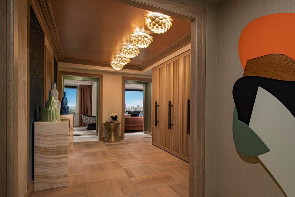 a hallway with a chandelier and a living room at JW Marriott Essex House New York in New York