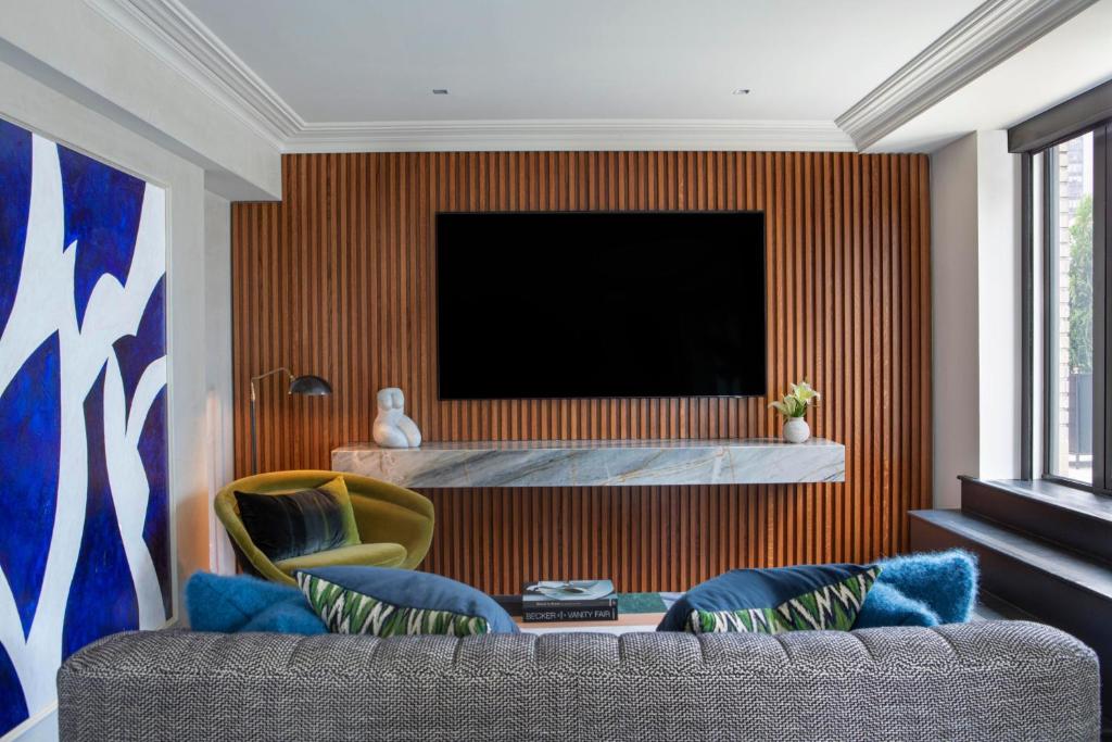 a living room with a couch and a television at JW Marriott Essex House New York in New York