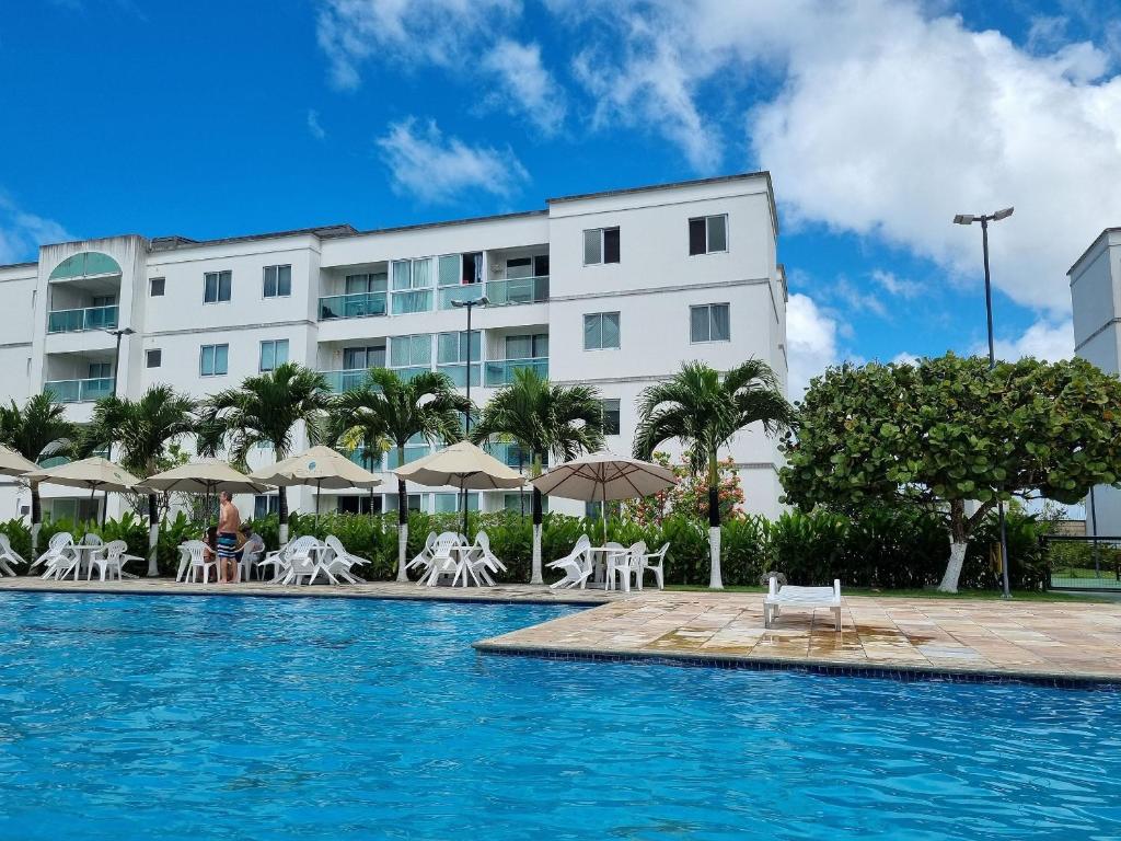 ein Schwimmbad vor einem Gebäude in der Unterkunft Palm Village Acqua Porto de Galinhas por Brevelar in Porto De Galinhas