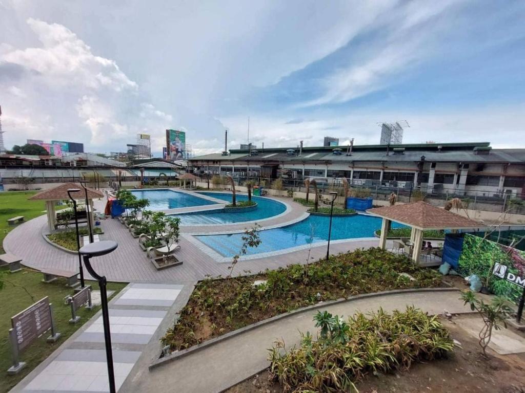 an outdoor swimming pool in a large building at 1BR Prisma Residences DMCI Stylish Condo in Manila