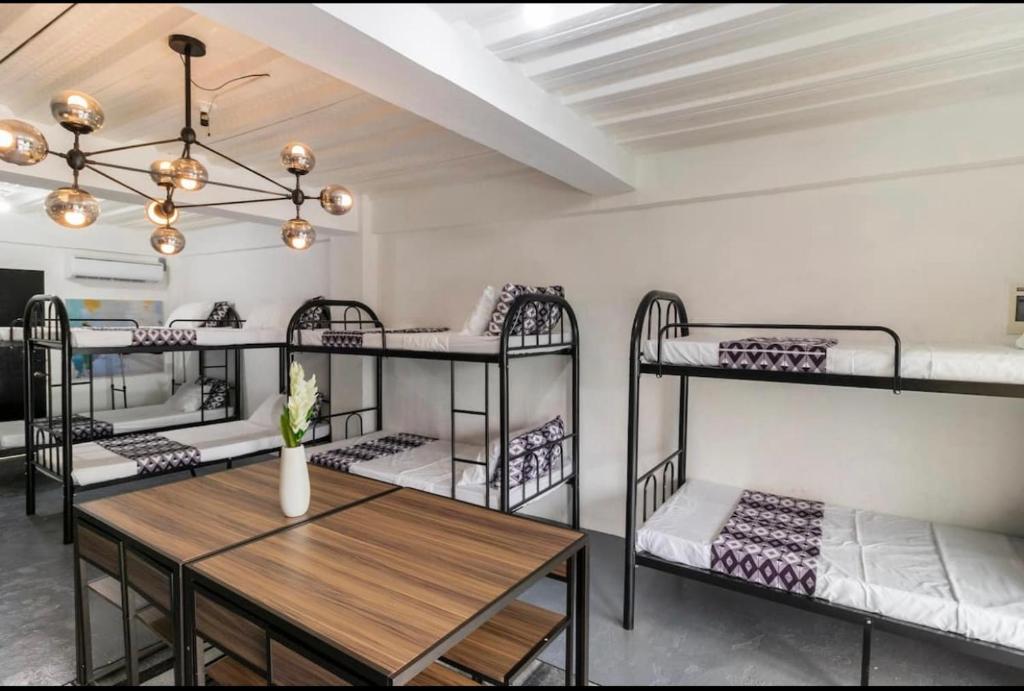 a room with four bunk beds and a table at Diamond Hall Cebu - 102 in Cebu City