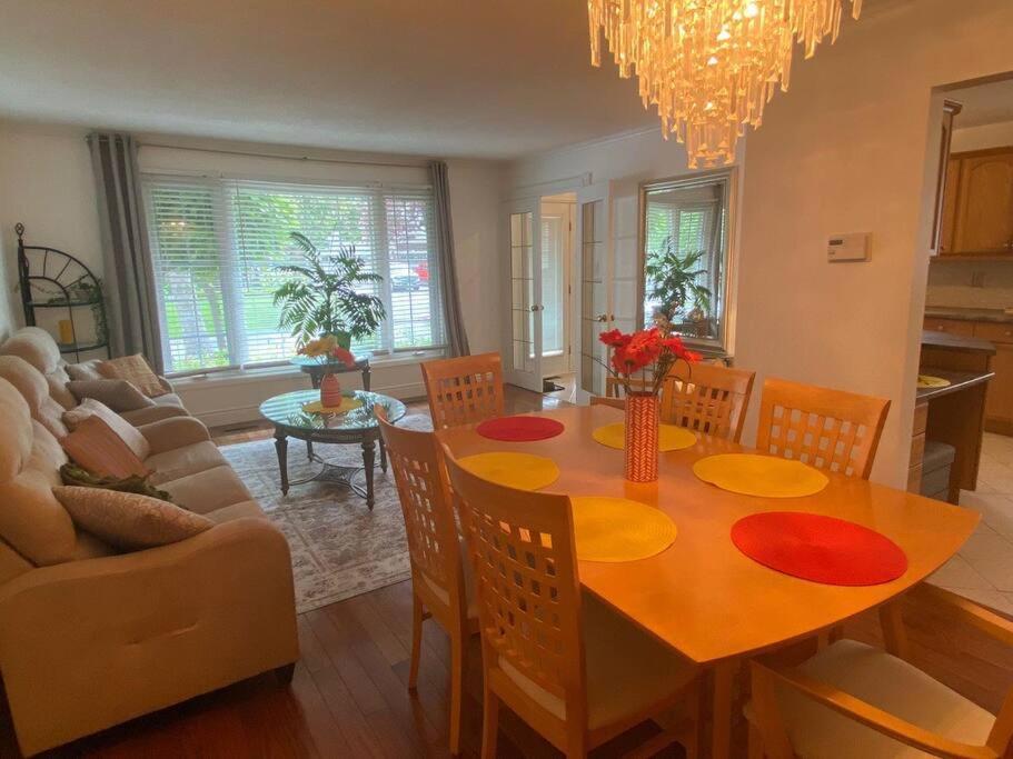 uma sala de jantar e sala de estar com mesa e cadeiras em Glengarry Haus Home Away From Home em Mississauga