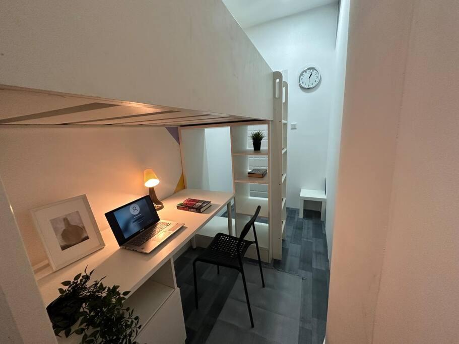 ordenador portátil en un escritorio en una habitación en Loft Style Partition Room in Shared Apartment in Al Barsha 1 Near MOE Metro, en Dubái