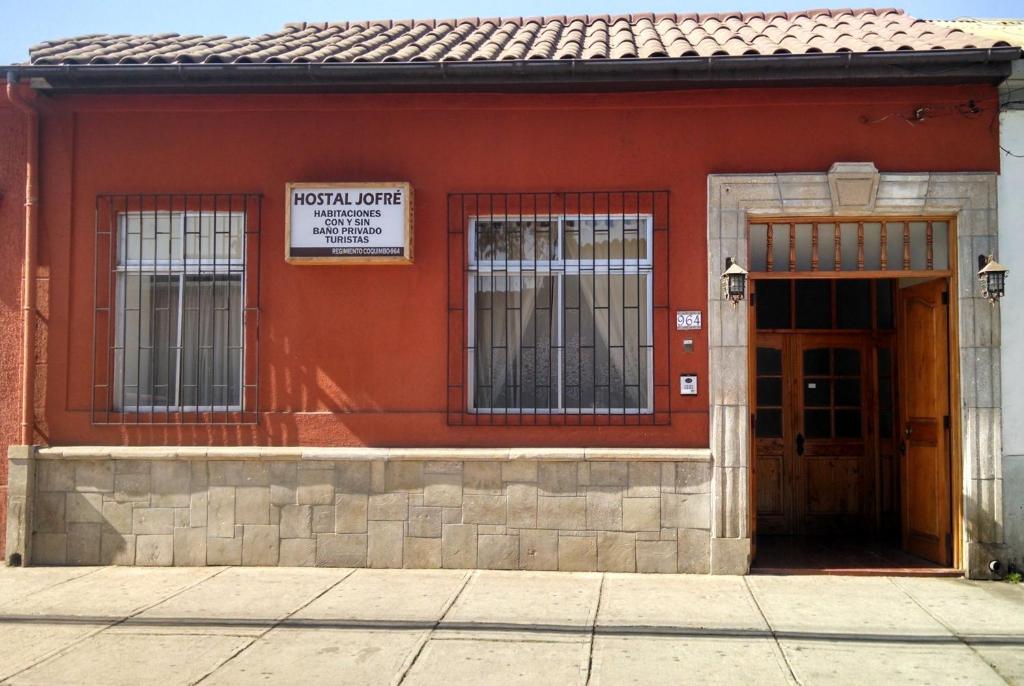 um edifício vermelho com um sinal que lê intérprete hospitalar em Piezas con Baño Privado Economicas em La Serena