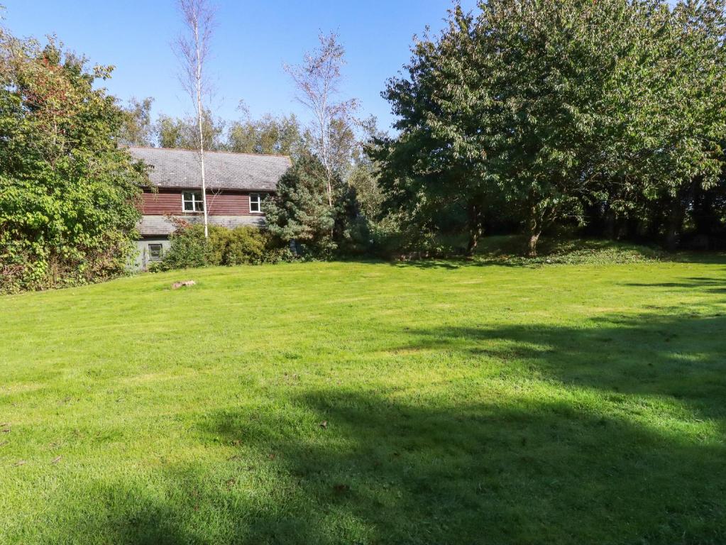 a large grassy yard with a house in the background at Spring Park Farmhouse in Launceston