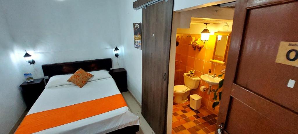 a small room with a bed and a bathroom at SANTANDER ALEMAN HOSTEL in San Gil