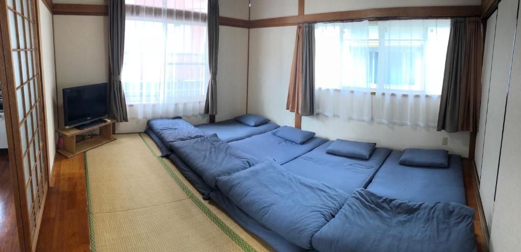 a bedroom with a bed in a room with a tv at Golden Mile Apartment in Amami